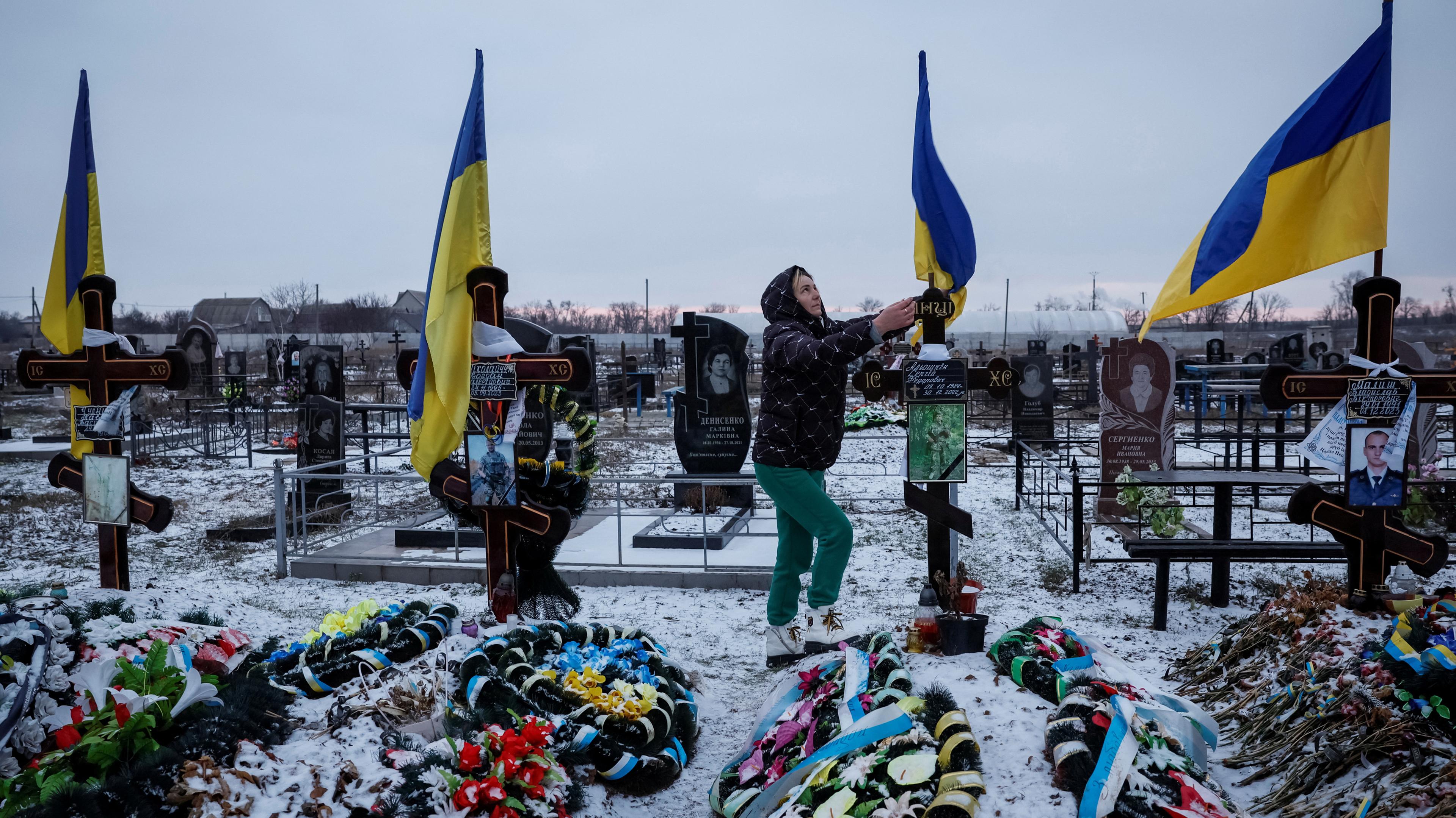Alona Onyshchuk, 39, besucht das Grab ihres Mannes in der Allee der Helden auf einem örtlichen Friedhof inmitten des russischen Angriffs auf die Ukraine im Dorf Lozuvatka, Region Dnipropetrovsk, 22.01.2024.