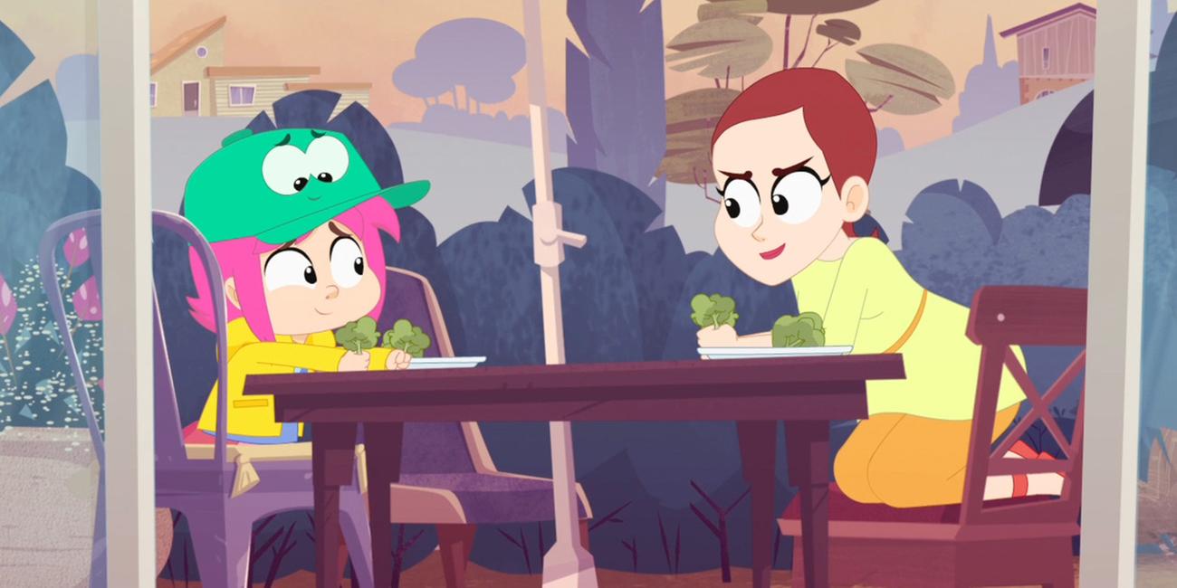 Rebecca und ihre Mutter sitzen sich am Gartentisch gegenüber. Beide haben Brokkoli in der Hand und lächeln sich zu. Auf Rebeccas Kopf sitzt Ernest in Hut-Form.