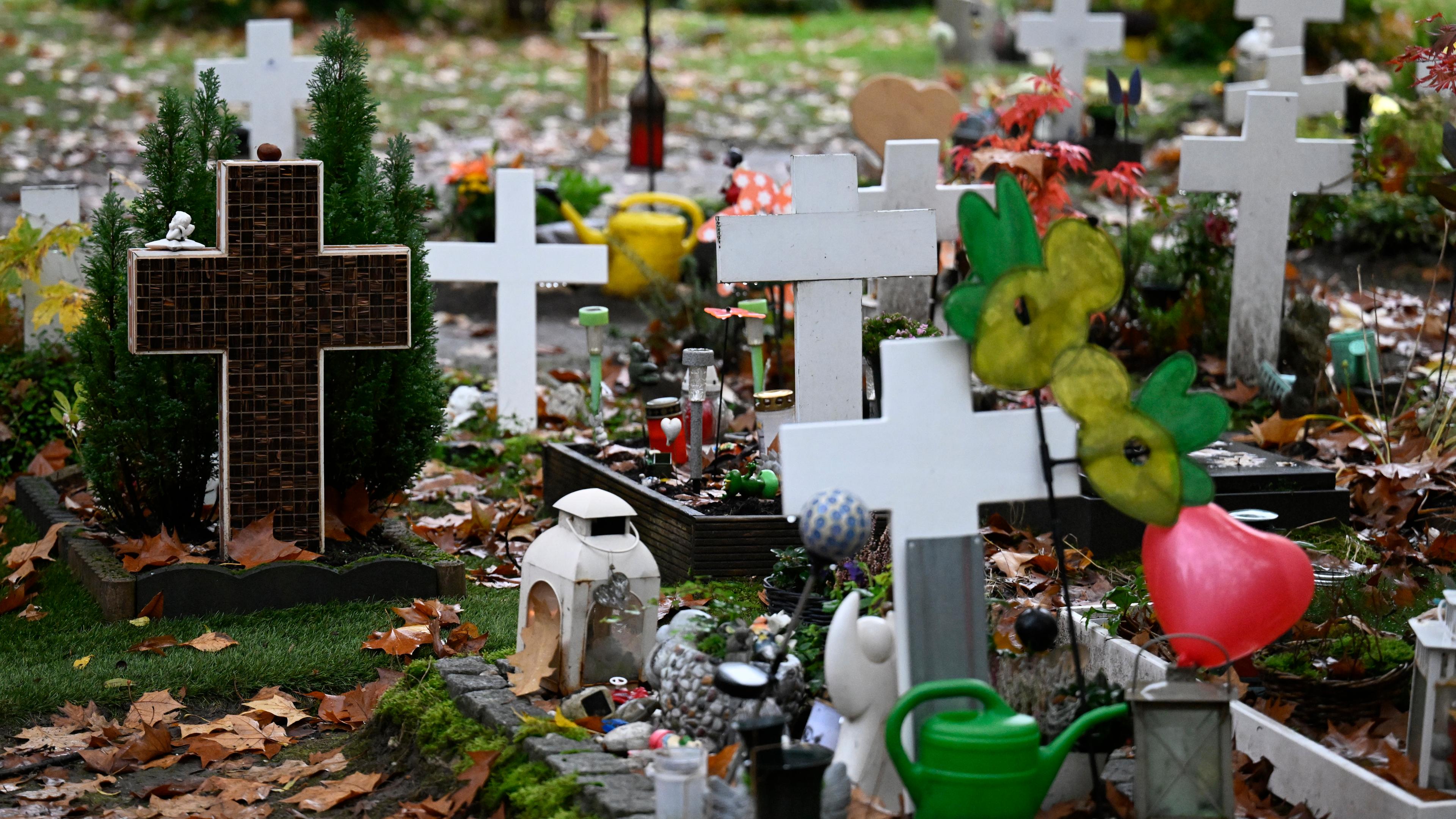 Grabkreuze stehen an Allerheiligen an Gräbern am Melatenfriedhof. 