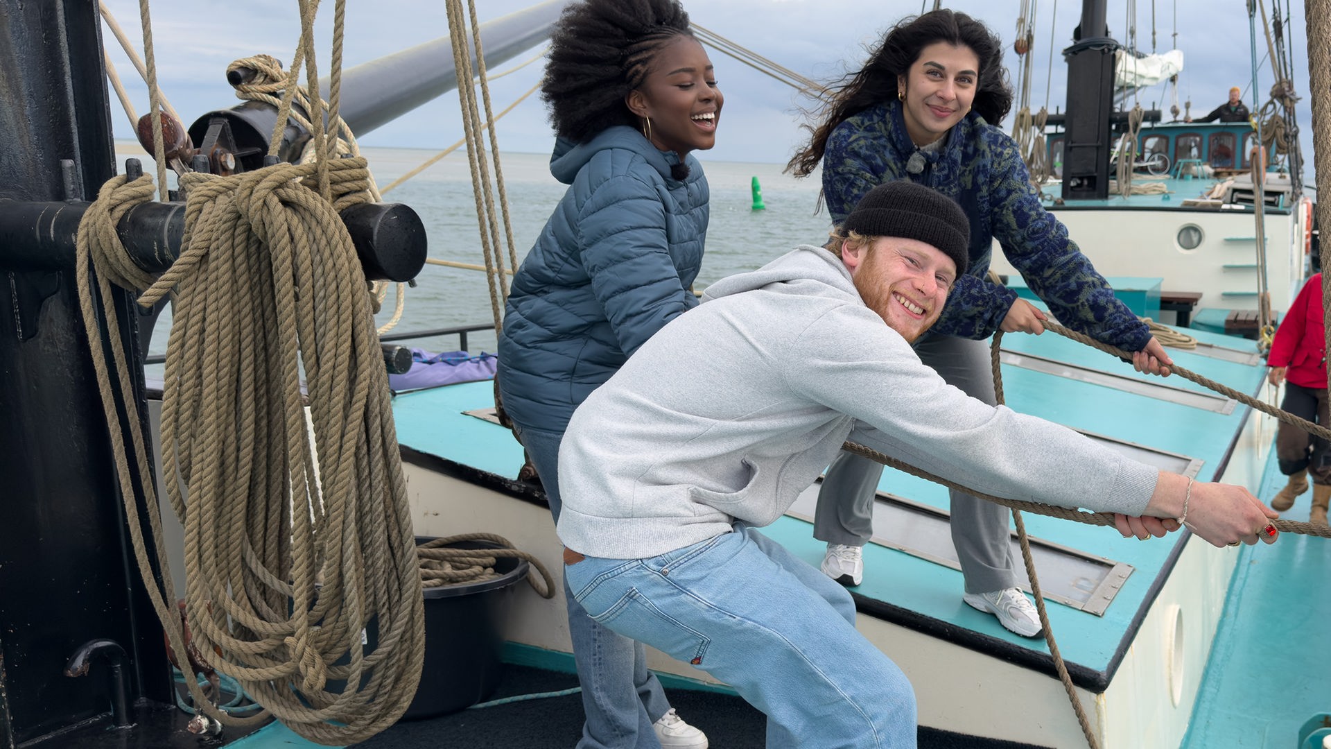 Jafait, Ella und Justus stehen auf einem Segelschiff und ziehen an einem Tau