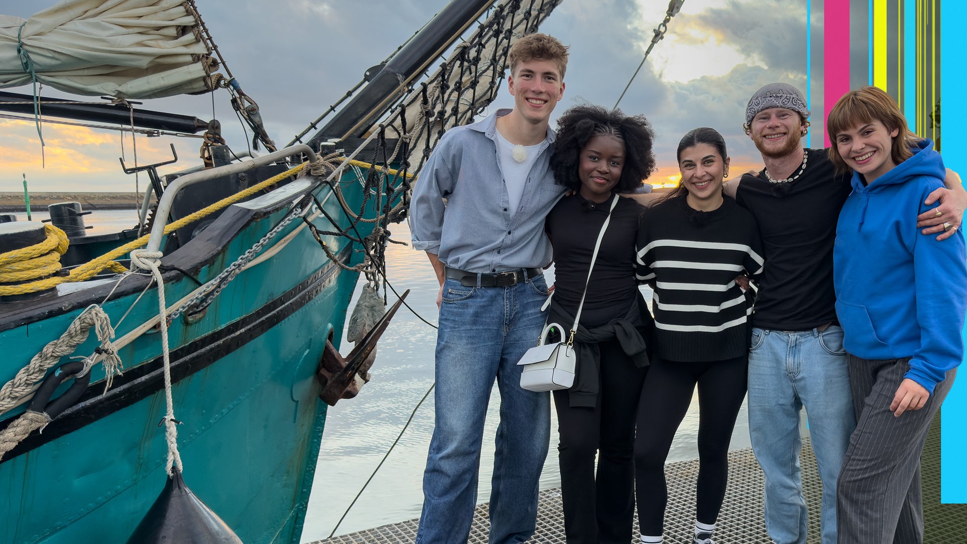 Rouven, Jafait, Ella, Justus und Angelina stehen im Hafen vor einem Segelschiff