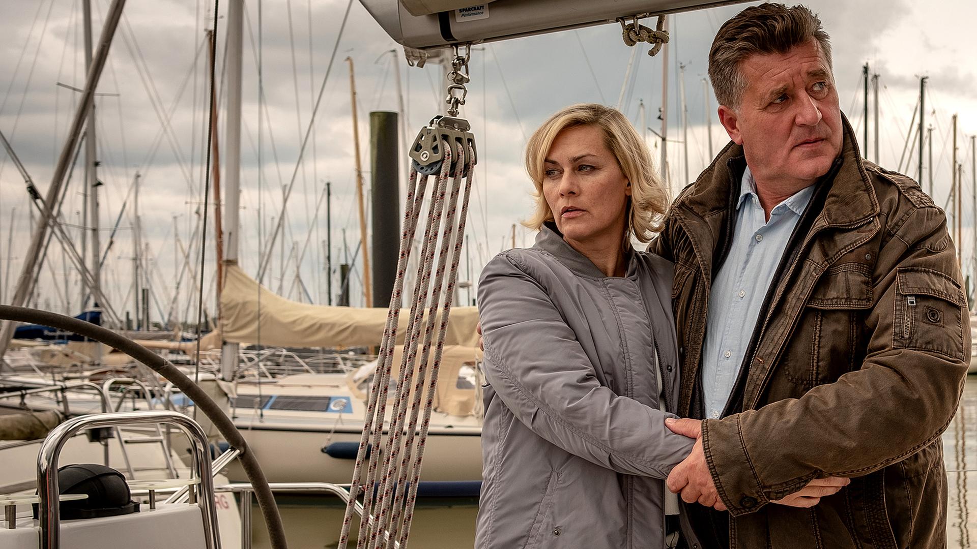 Ines Hauber (Gesine Cukrowski) und Hans Moor (Bruno F. Apitz) stehen nebeneinander Arm in Arm auf einem Steg an dem viele Segelboote liegen.
