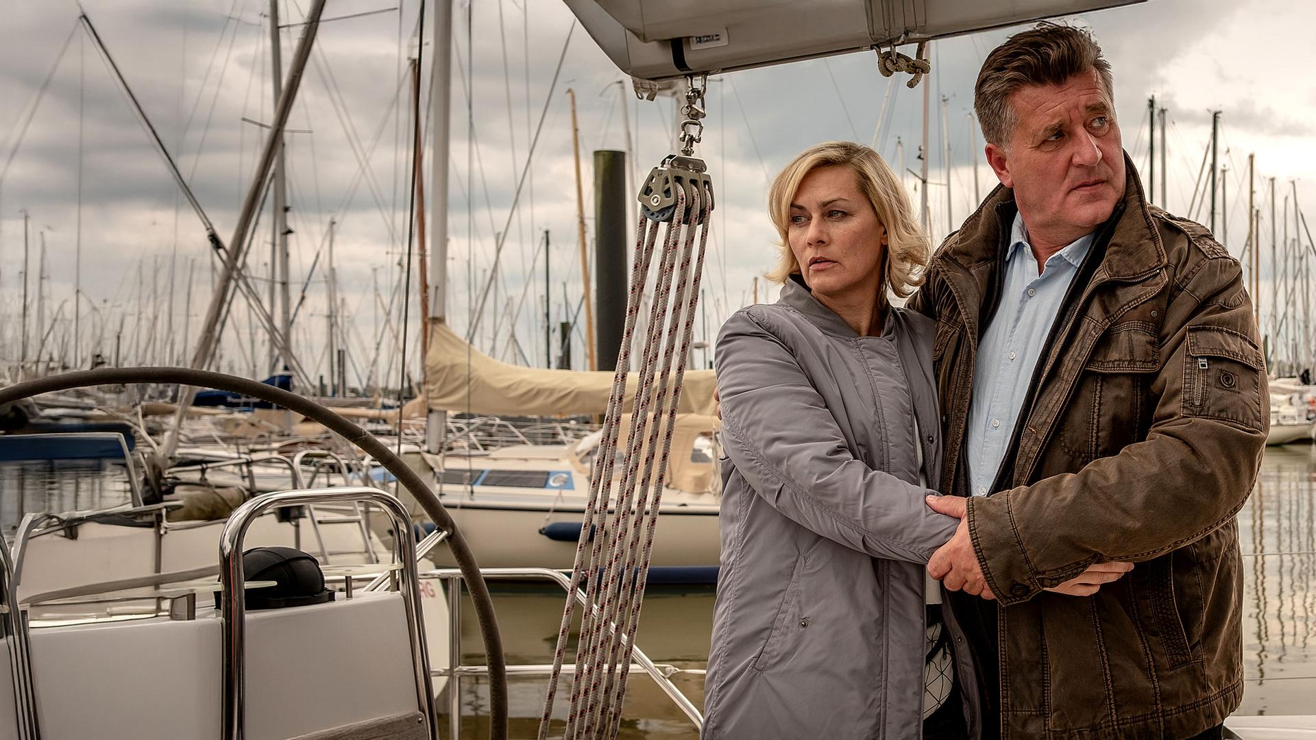 Ines Hauber (Gesine Cukrowski) und Hans Moor (Bruno F. Apitz) stehen nebeneinander Arm in Arm auf einem Steg an dem viele Segelboote liegen.