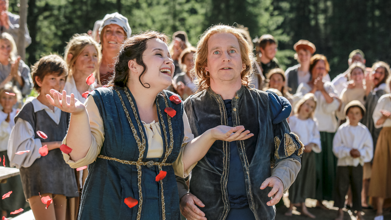 Die Triebel Irmel (Carolin Walter, rechts) und Wenzel (Karsten Kramer, links) vor einer Menge Statisten