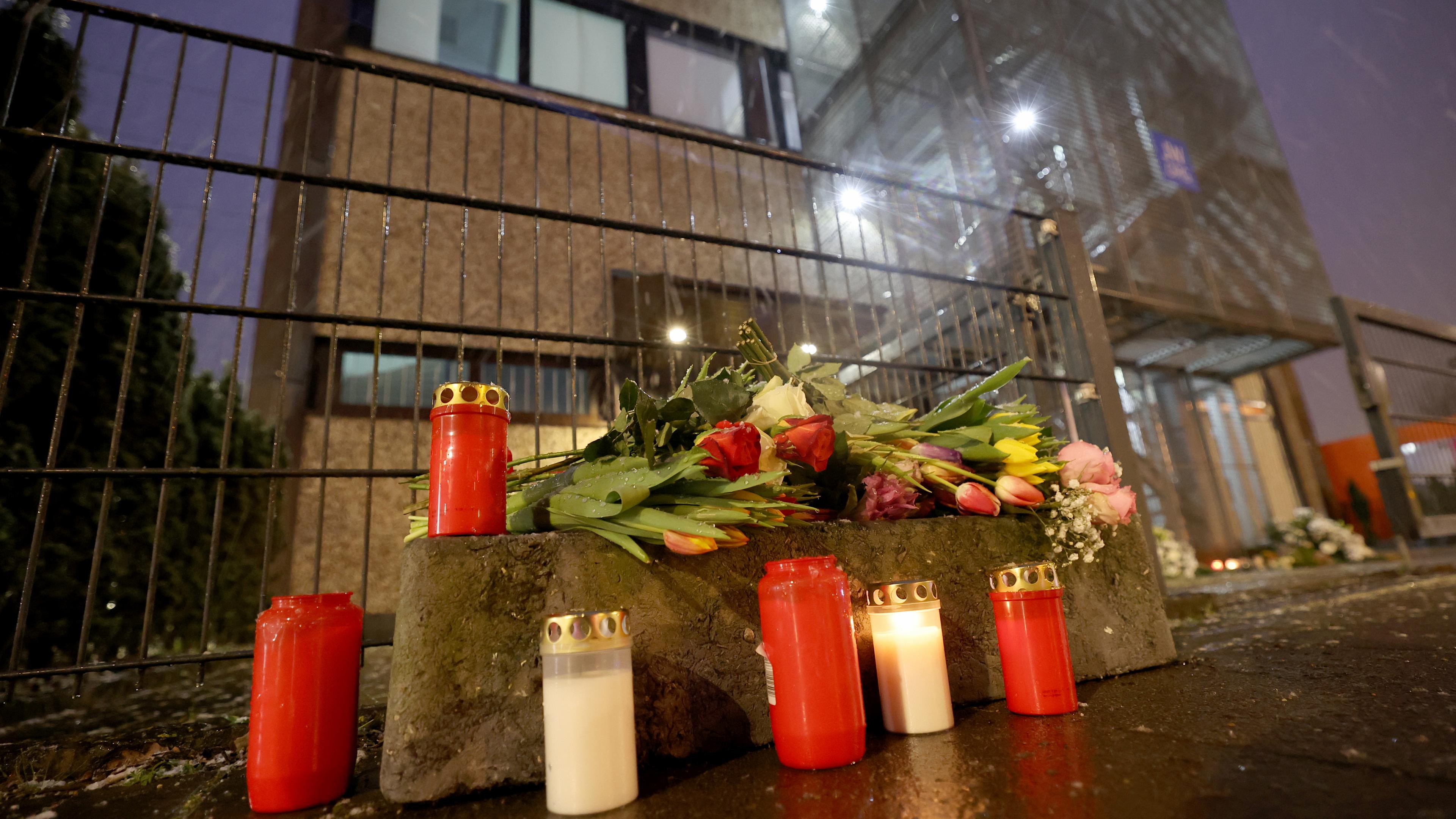 Das Bild zeigt Grablichter und Blumen vor dem Gebäude der Zeugen Jehovas im Stadtteil Alsterdorf.