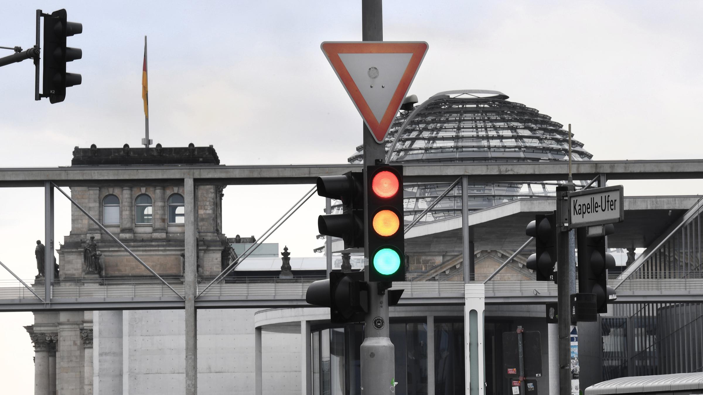Ampel leuchtet in allen Farben vor der Kuppel des Reichstagsgebäudes
