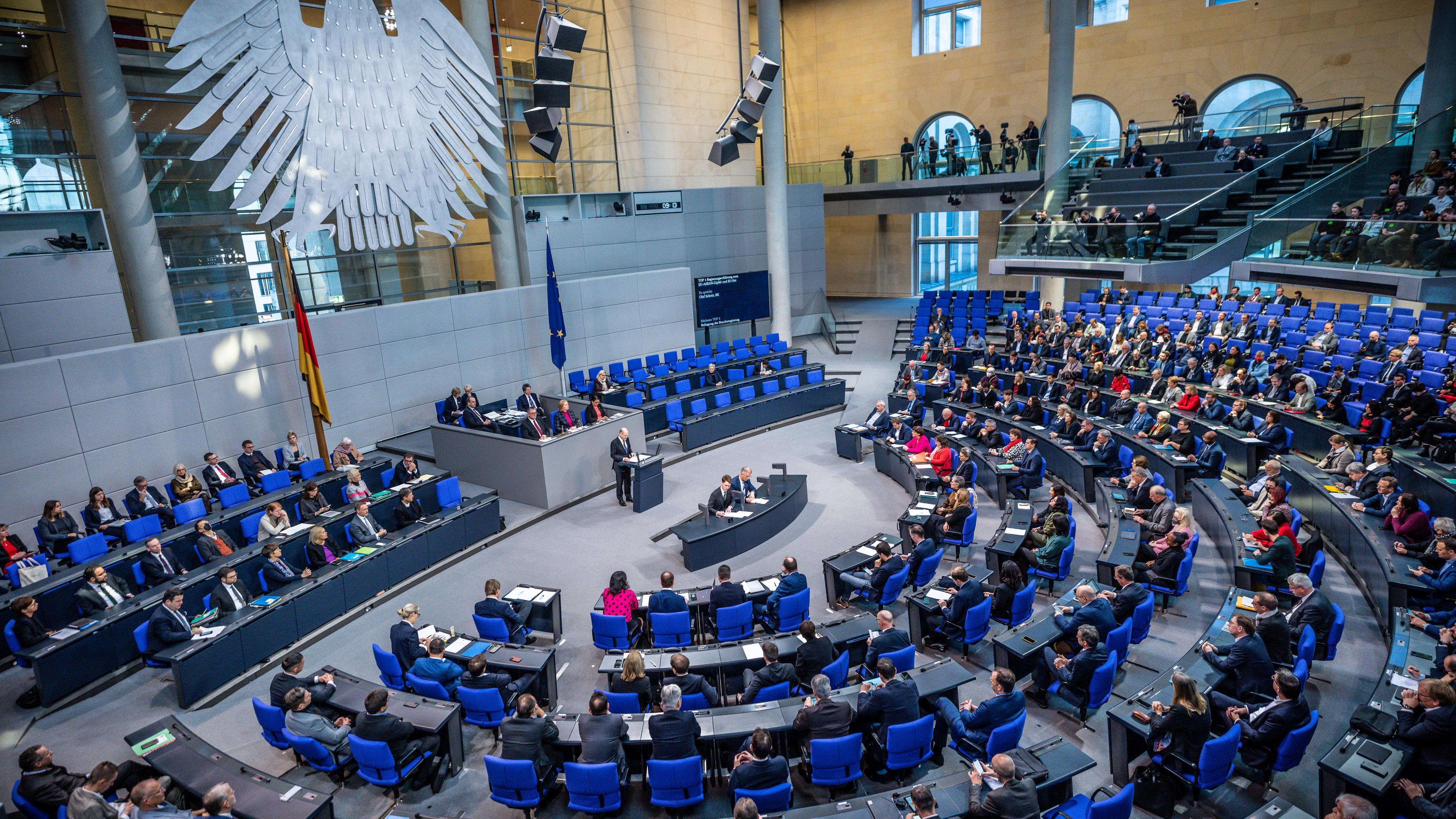 undeskanzler Olaf Scholz (M, SPD) gibt bei der Sitzung des Bundestags eine Regierungserklärung zum EU-Rat und zum EU-/Asean-Gipfel ab.
