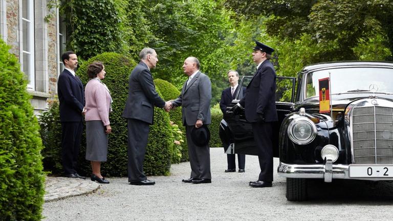 Szene während der Dreharbeiten zu "An einem Tag im September": Die Darsteller von Charles de Gaulle und Konrad Andenauer geben sich zur Begrüßung die Hände.