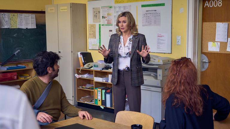 Frau Marx (Veronica Ferres, M.) hat schlechte Neuigkeiten für Jannos (Jasin Challah, l.), Nike (Henny Reents, r.) und die anderen Lehrkräfte: Die Schule muss schließen!