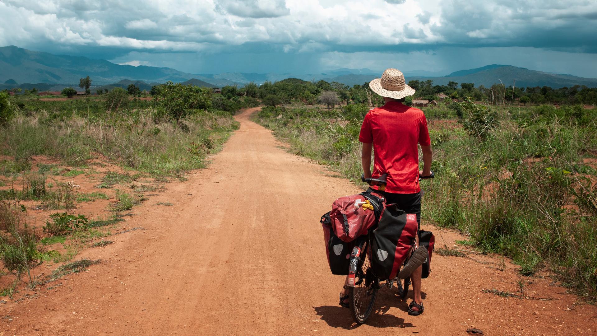 Anselm Nathanael Pahnke von hinten auf Fahrrad. Er blickt in die Landschaft.