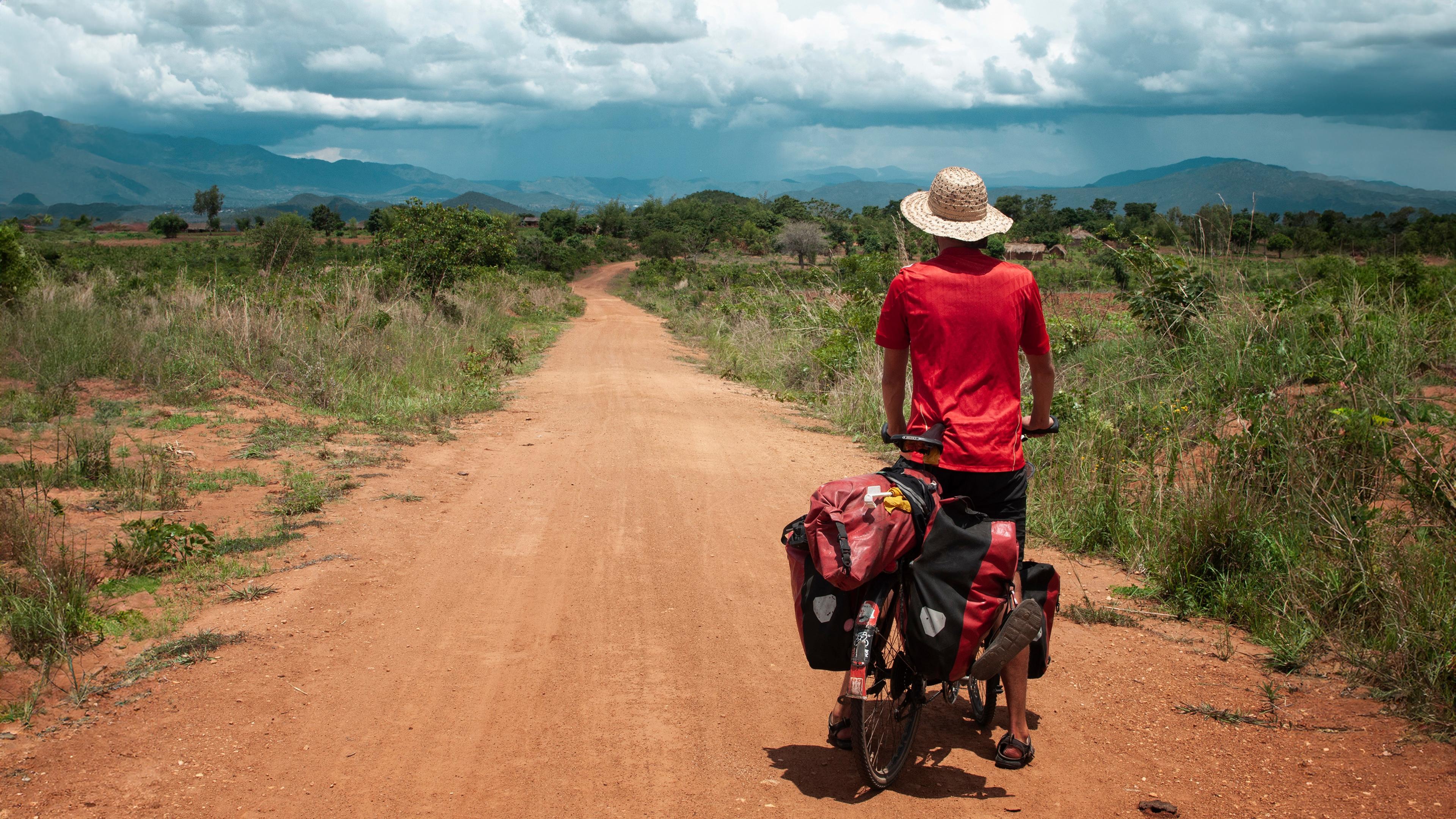 Anselm Nathanael Pahnke von hinten auf Fahrrad. Er blickt in die Landschaft.