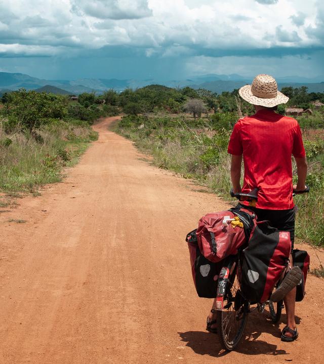Anselm Nathanael Pahnke von hinten auf Fahrrad. Er blickt in die Landschaft.