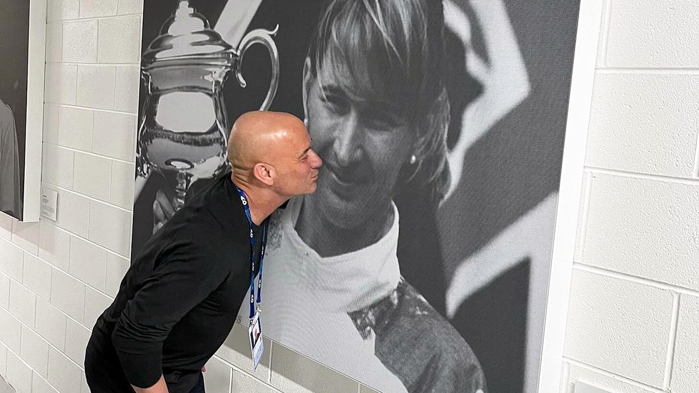 Andre Agassi küsst symbolisch ein Plakat, auf dem Steffi Graf abgebildet ist