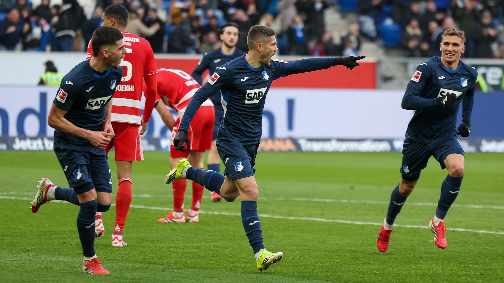 Hoffenheims offensiver Mittelfeldspieler jubelt zusammen mit seinen Teamkollegen Albian Hajdari und Grischa Proemel nach seinem Treffer zum 2:0 gegen den 1. FC Union Berlin  