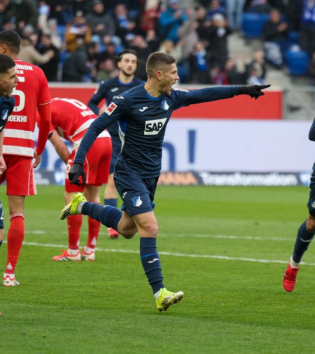 Hoffenheims offensiver Mittelfeldspieler jubelt zusammen mit seinen Teamkollegen Albian Hajdari und Grischa Proemel nach seinem Treffer zum 2:0 gegen den 1. FC Union Berlin  