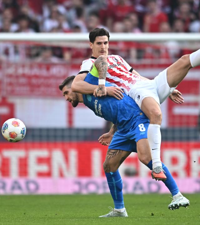 Leverkusens Mittelfeldspieler Robert Andrich und Freiburgs Mittelstürmer Igor Matanović kämpfen um den Ball