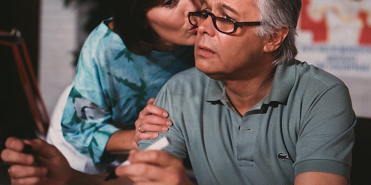 Werner schaut verunsichert in die Ferne, Angi gibt ihm einen Kuss auf die Wange.