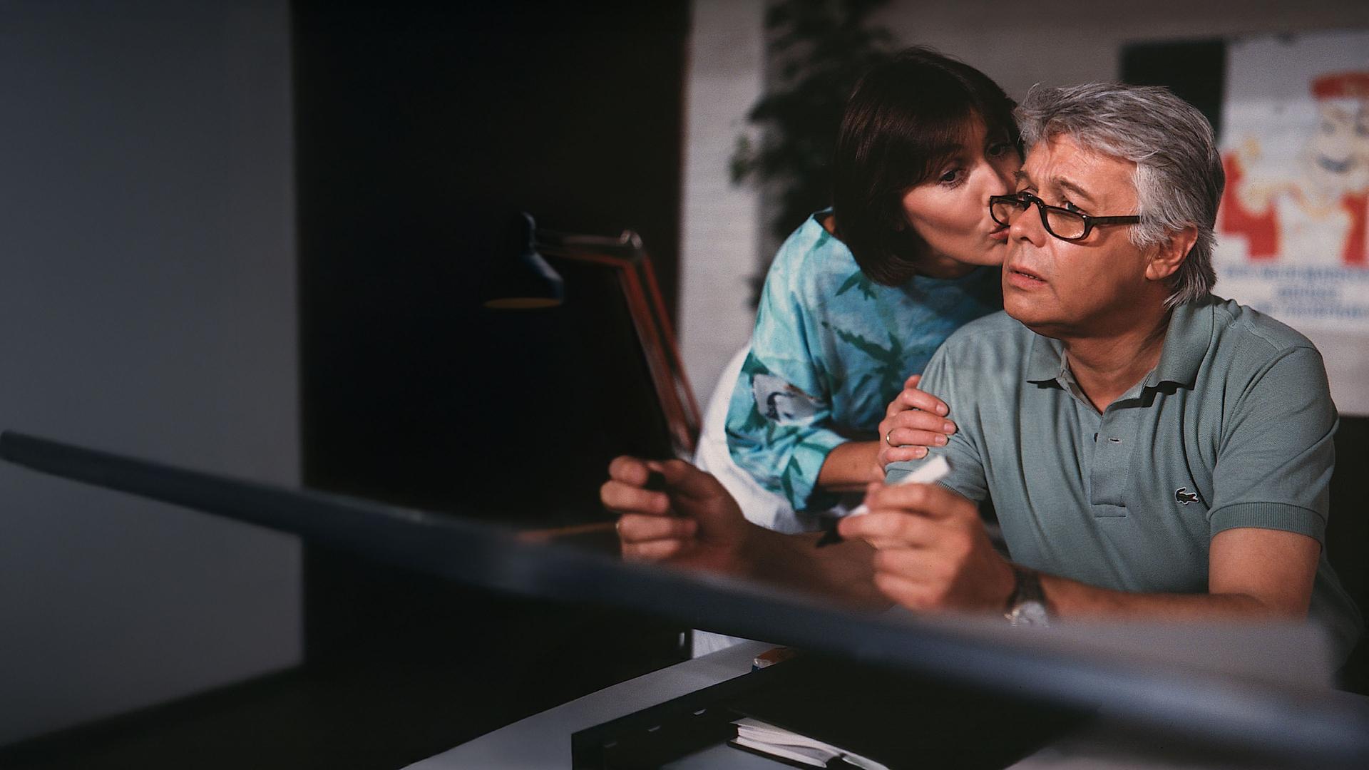 Werner schaut verunsichert in die Ferne, Angi gibt ihm einen Kuss auf die Wange.