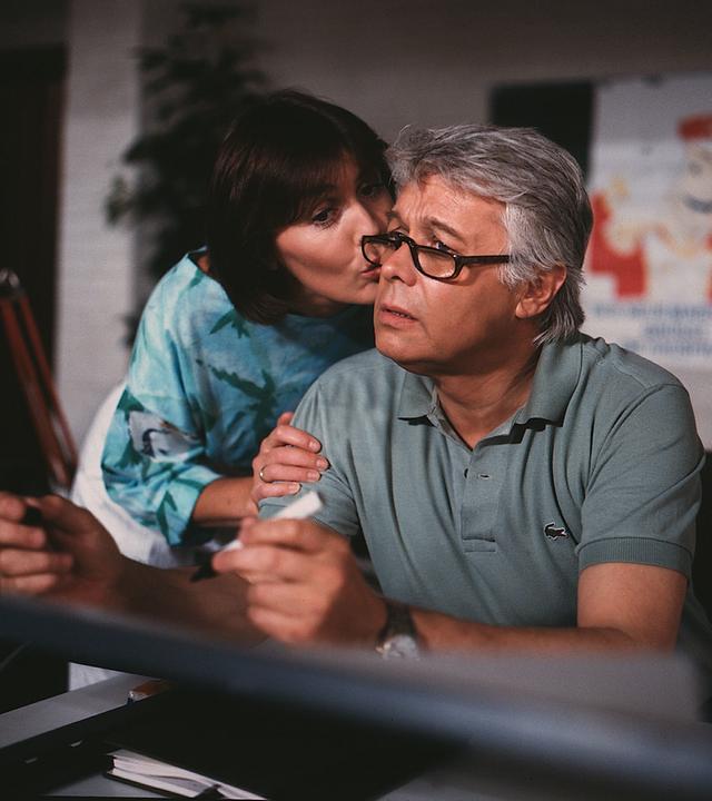 Werner schaut verunsichert in die Ferne, Angi gibt ihm einen Kuss auf die Wange.