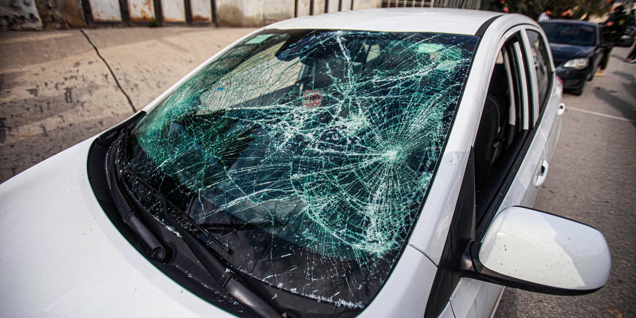 Die durch Steinwürfe beschädigte Glasscheibe eines Autos.
