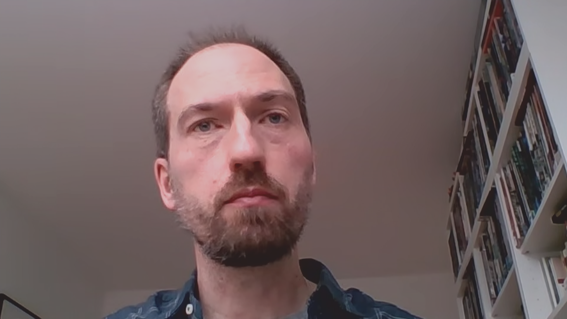 Gewaltforscher Prof. Jonas Rees neben einem Bücherregal