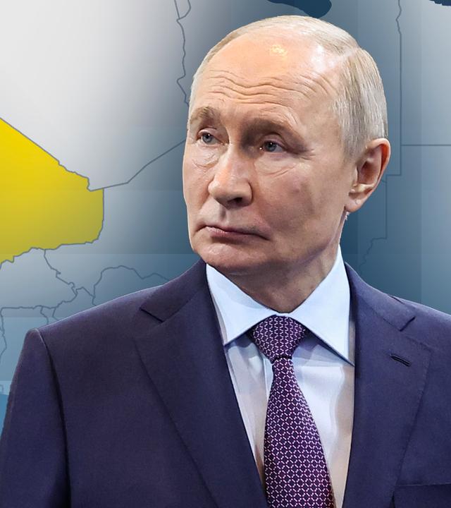 Der russische Präsident Putin. Hinter ihm eine Karte des afrikanischen Kontinens, bei der das Land Mali gelb markiert ist.