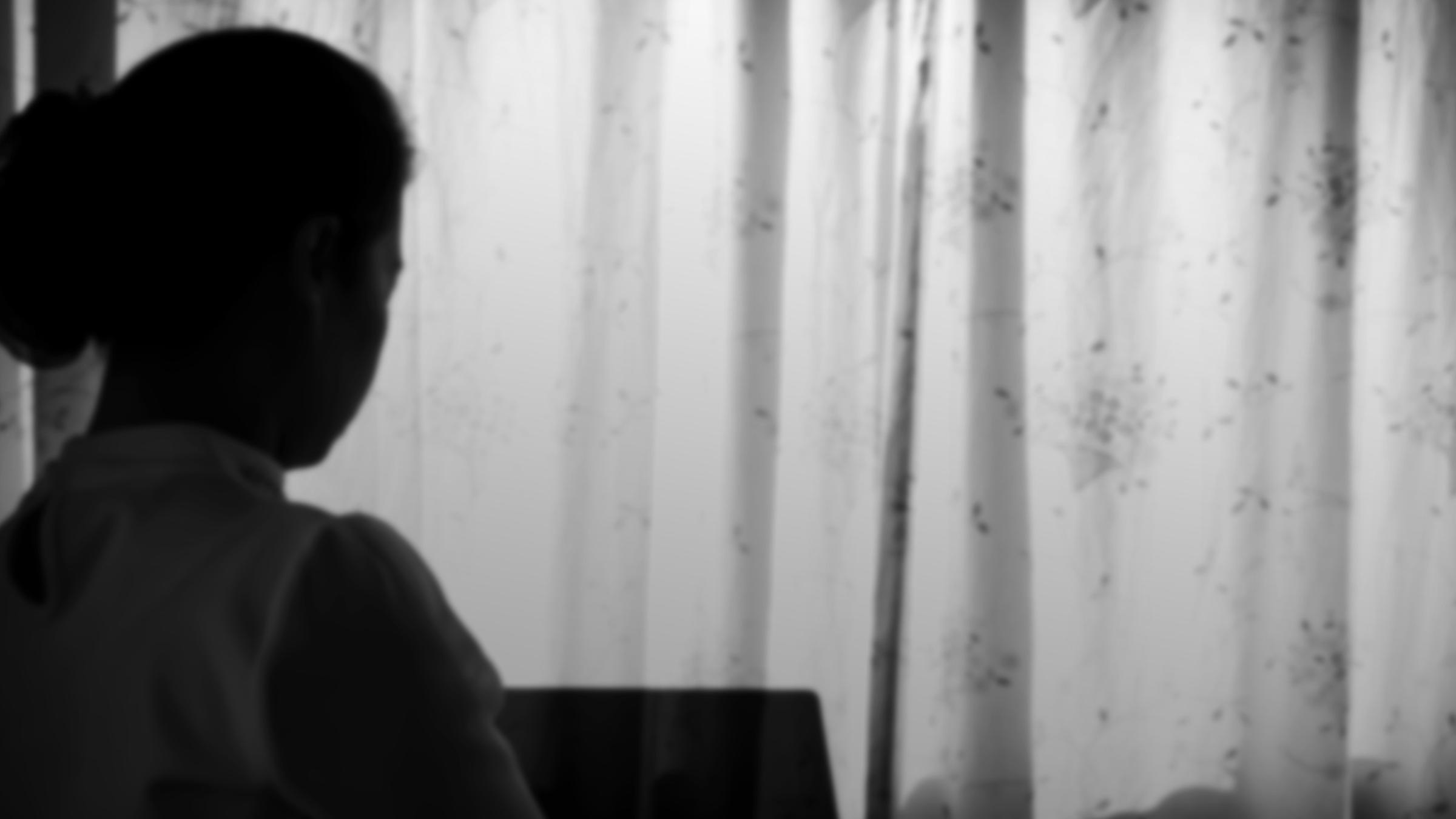 Symbolbild Angststörung: Frau hinter geschlossenem Vorhang