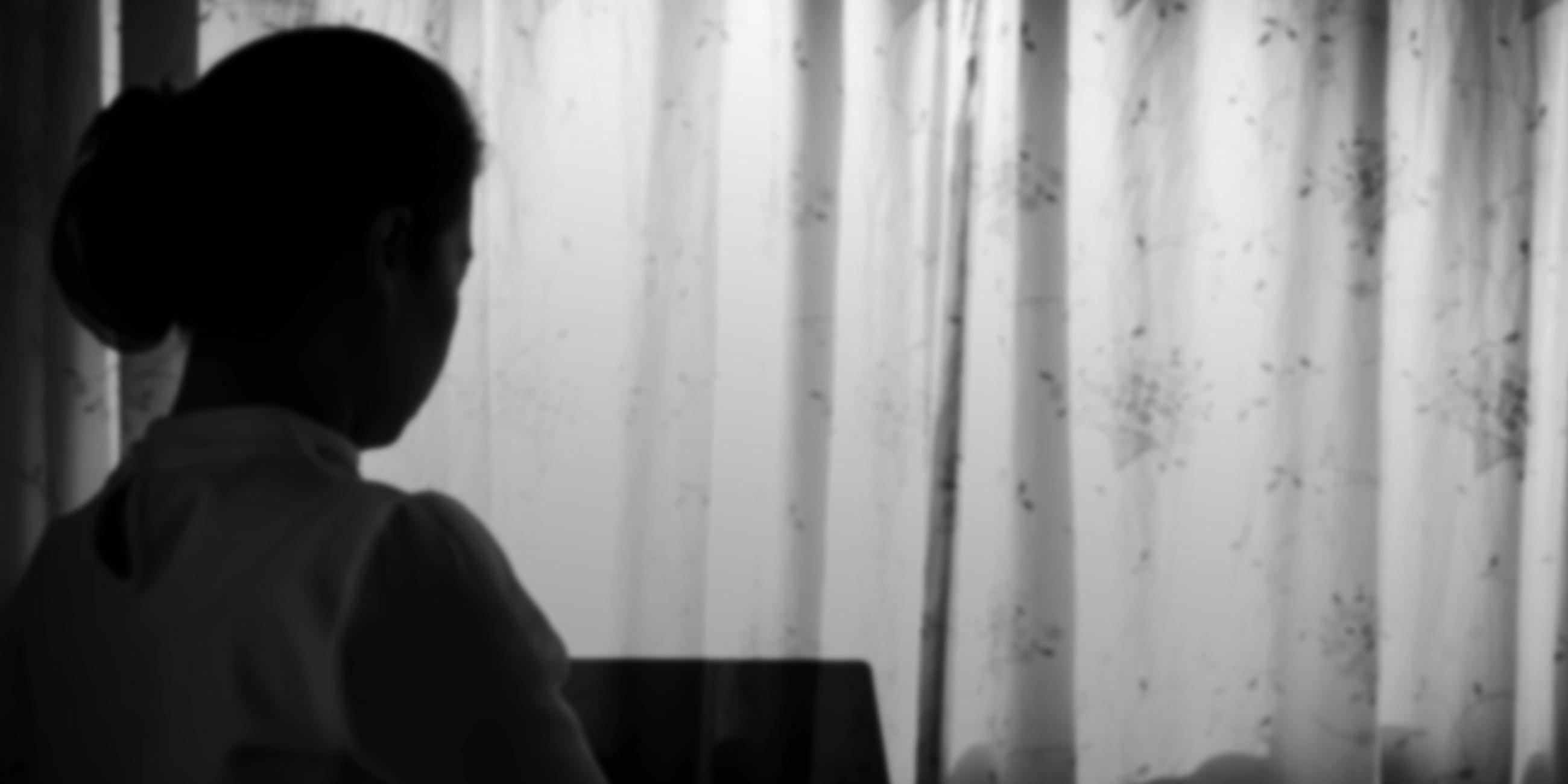 Symbolbild Angststörung: Frau hinter geschlossenem Vorhang