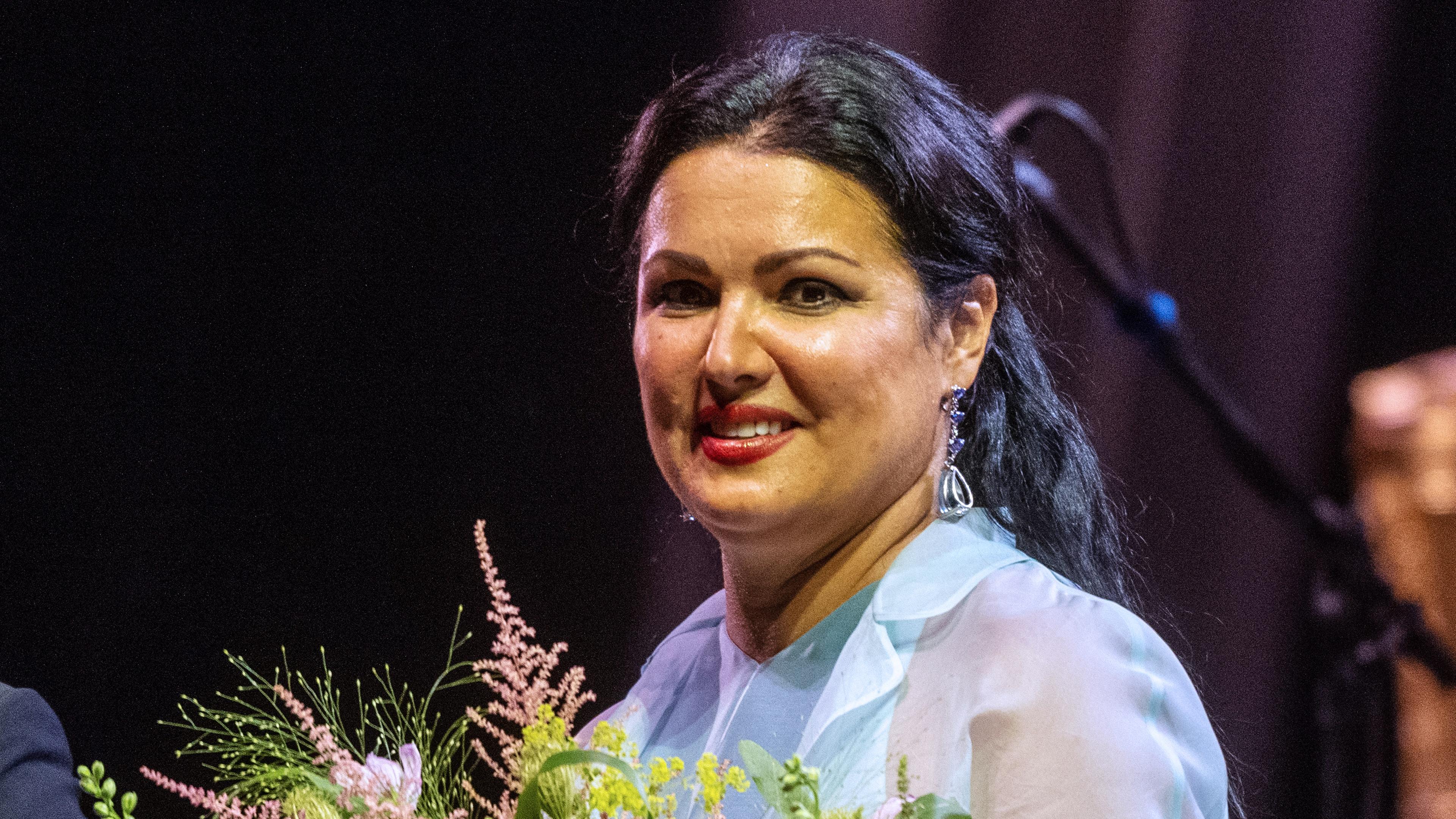 Die Opernsängerin Anna Netrebko mit einem Blumenstrauß auf der Bühne.