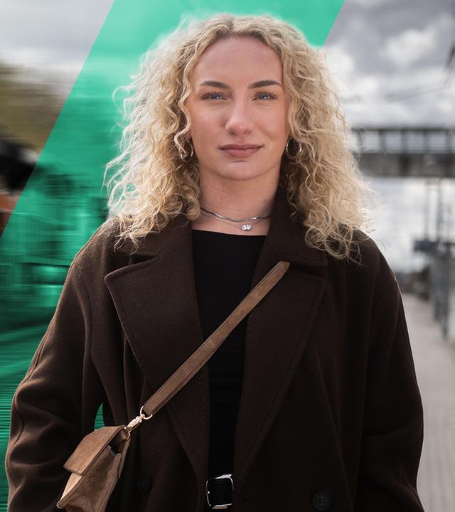 Anna (rechts im Bild) schaut in die Kamera - links im Hintergrund sieht man einen Zug