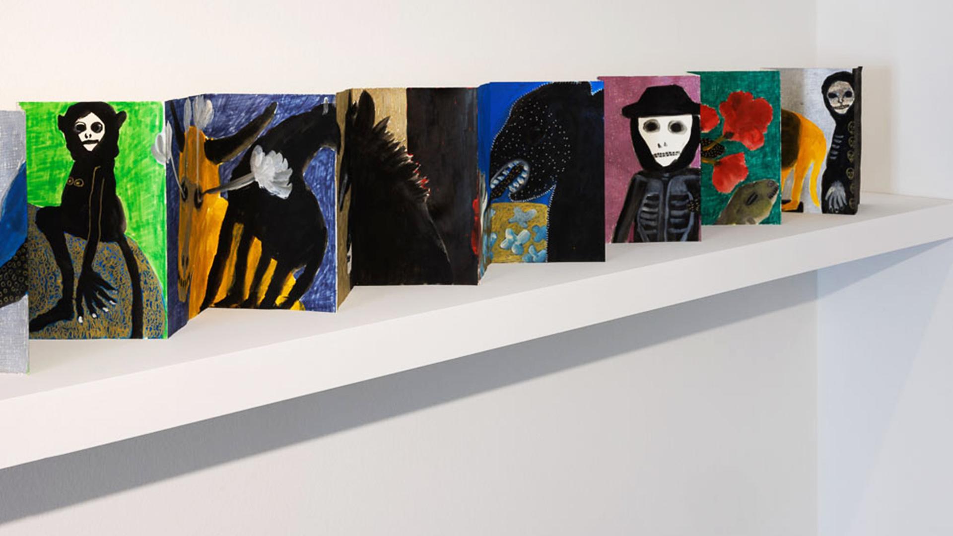 Leporello mit kleinen Gemälden von Figuren und Tieren