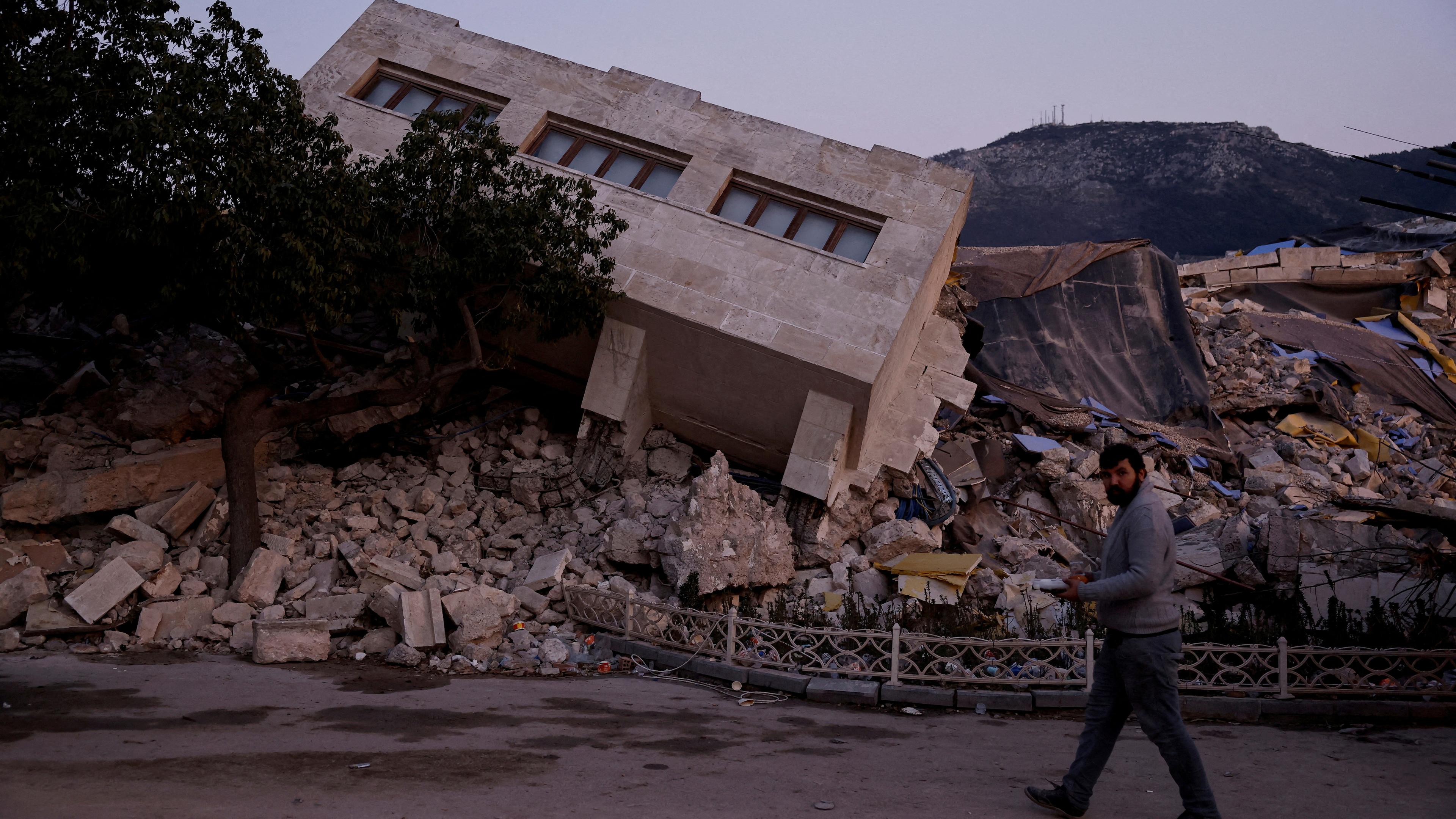 Ein Mann läuft an einem zerstörten Haus in der türkischen Stadt Antakya vorbei