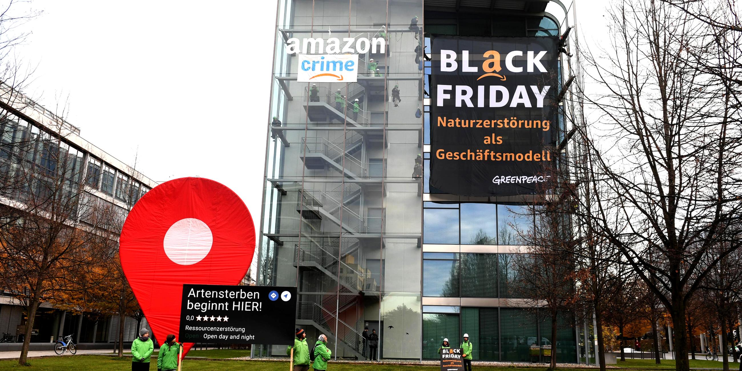 Greenpeace-Aktivisten protestieren während der Rabattaktion Black Friday gegen die Ressourcenverschwendung des Online-Versandhändlers Amazon und hängen dort Plakate auf mit der Aufschrift "crime" und "Black Friday - Naturzerstörung als Geschäftsmodell".