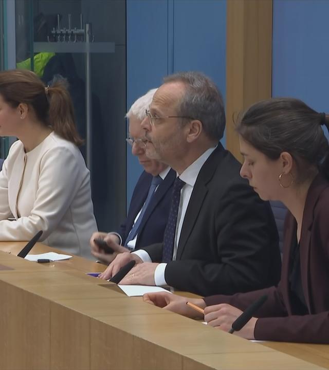 Auf dem Bild sieht man verschiede Politiker am Tisch sitzen.