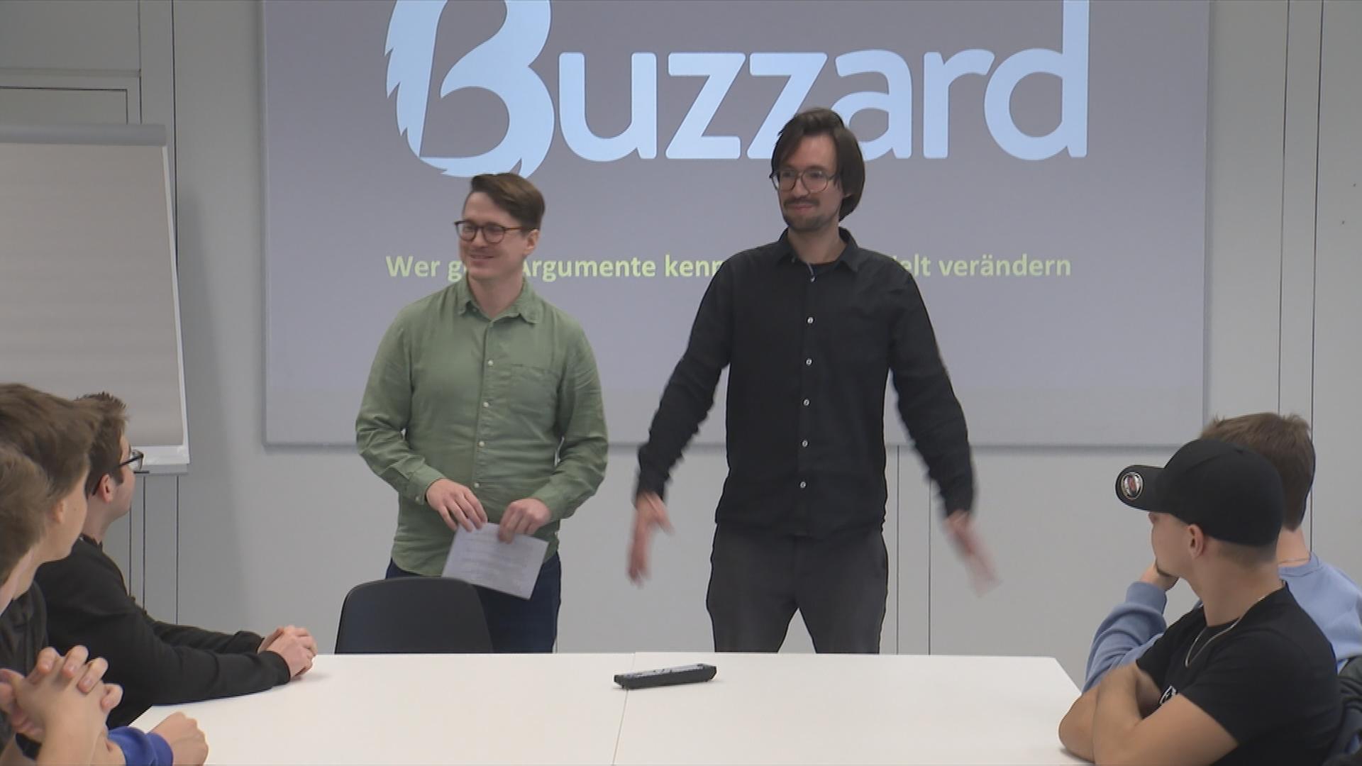 Auf dem Bild sieht man wie die zwei Gründer die neue App Buzzard vortellen.