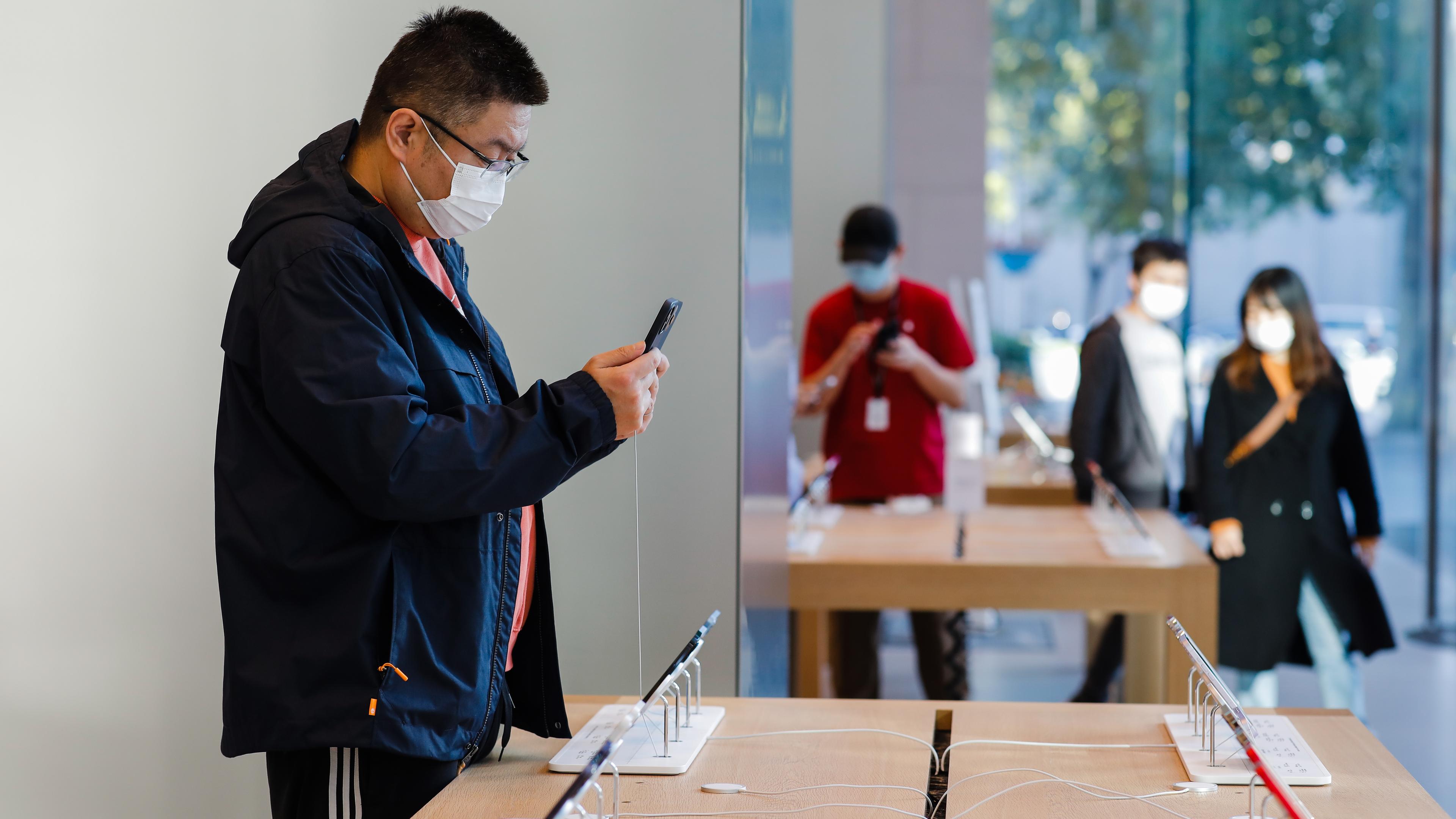 Leute schauen sich i-Phone 14-Modelle in einem Apple Store in Peking an