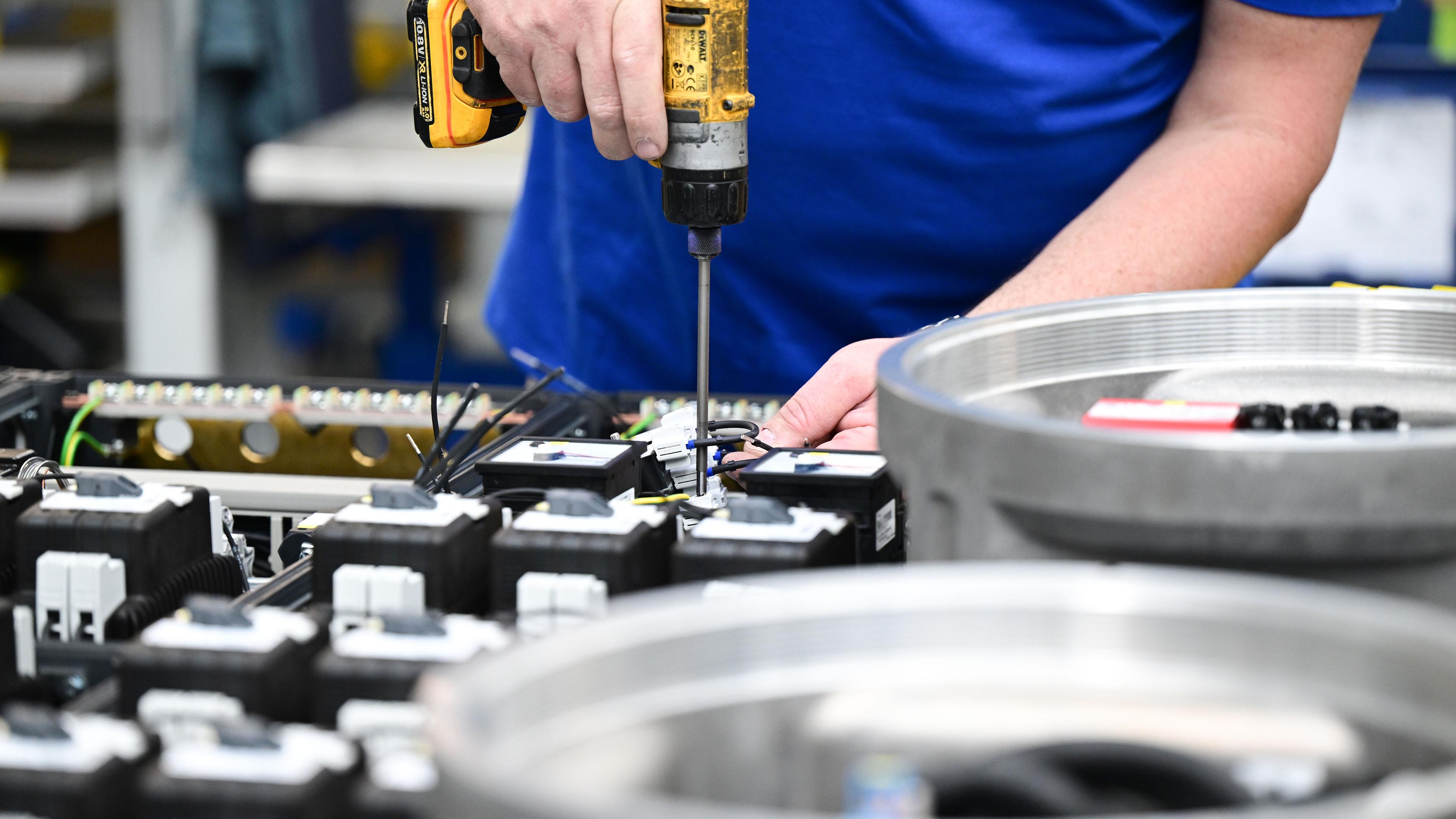 Baden-Württemberg, Waldenburg: Ein Arbeiter fertigt einen explosionsgeschützen Schaltkasten in einer Produktionshalle