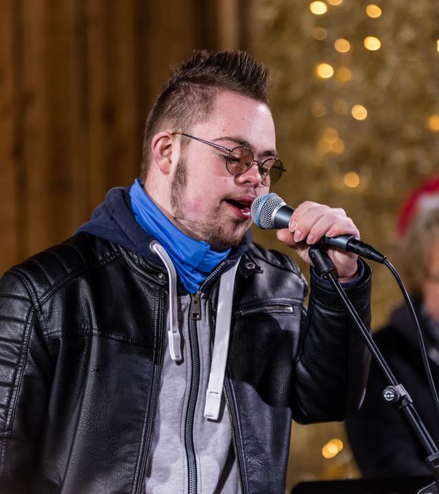 "Dein Song - Arbeiten mit den Profimusikern": Der "Dein Song" Kandidat Lucas steht mit dem Mikrofon in der rechten Hand in der "Dein Song" Scheune und singt.