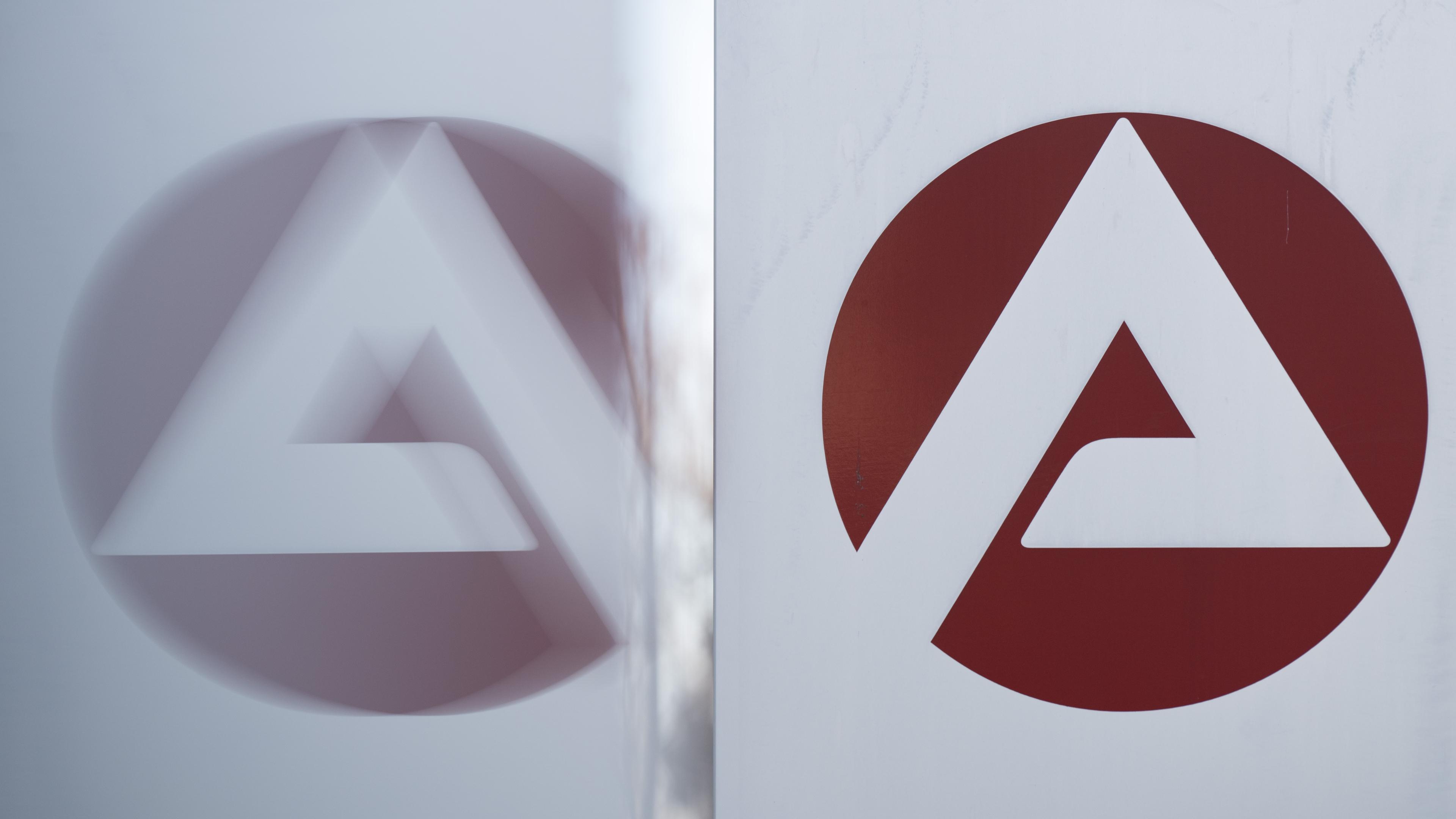 ARCHIV - 03.01.2023, Sachsen, Dresden: Das Logo der Bundesagentur für Arbeit spiegelt sich in einer Scheibe. 