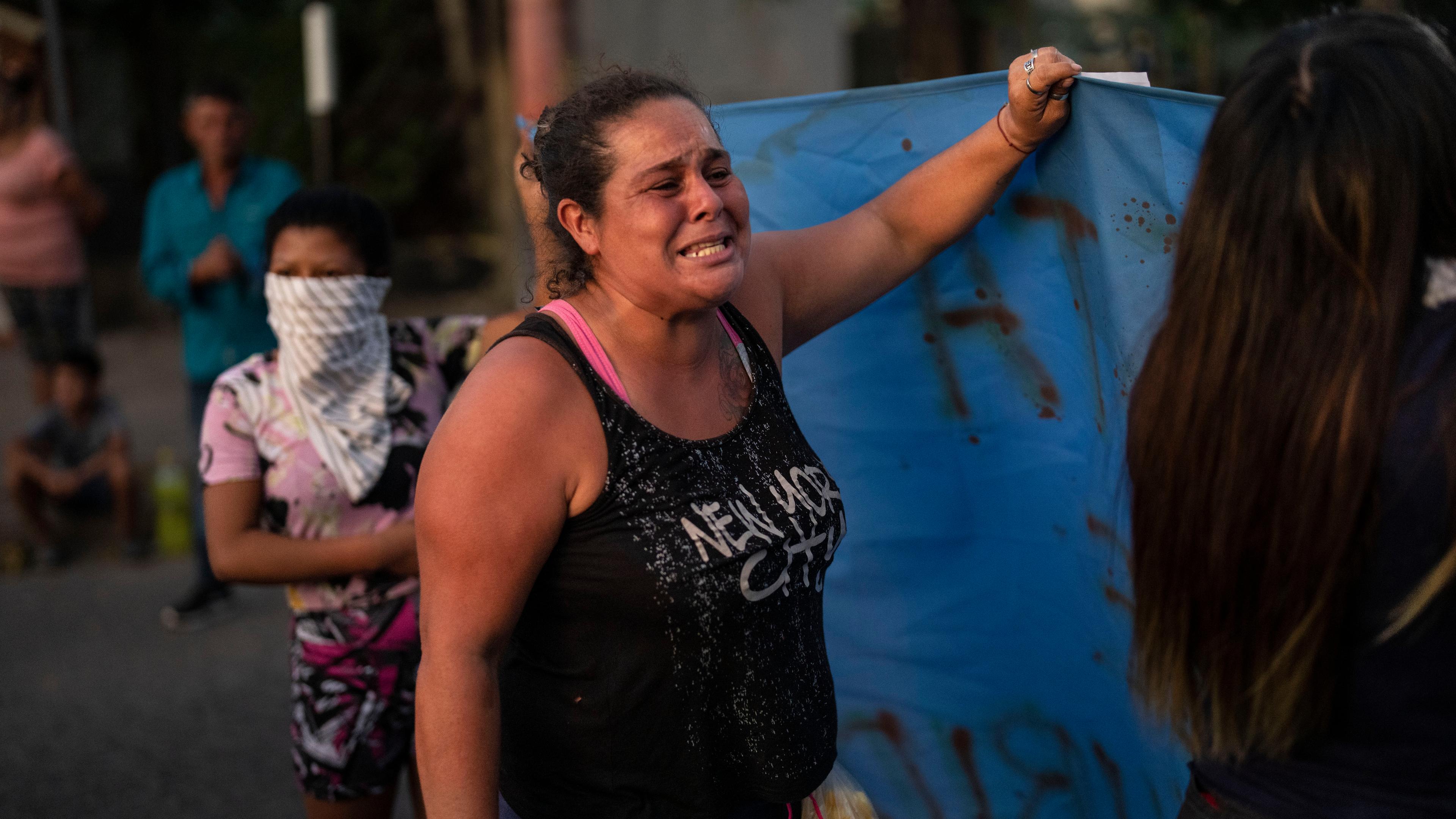 Mutter eines getöteten Jungen weint und hält mit anderen Frauen ein Banner hoch
