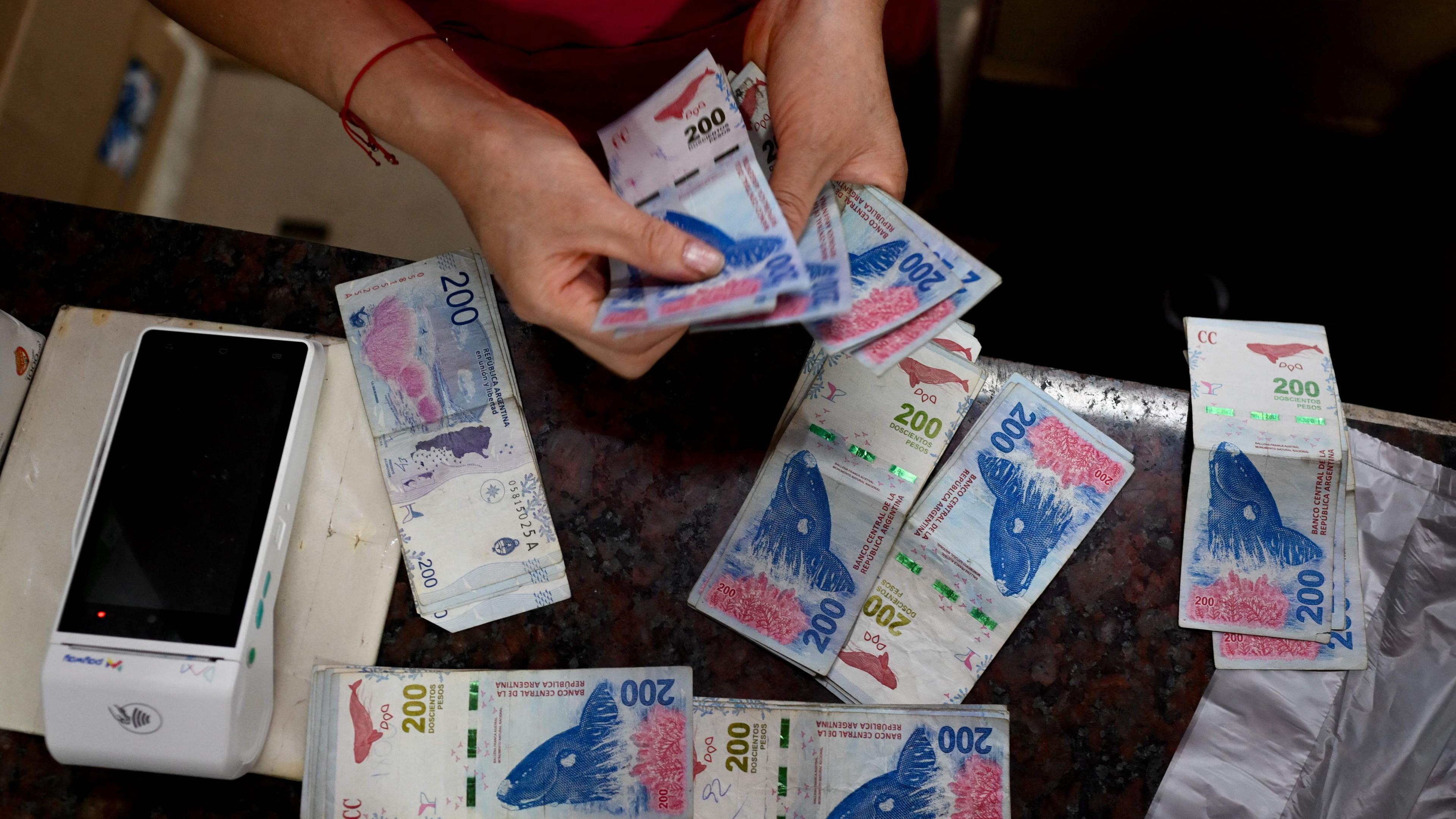 Eine Frau zählt Geld auf einem Markt in Argentinien.