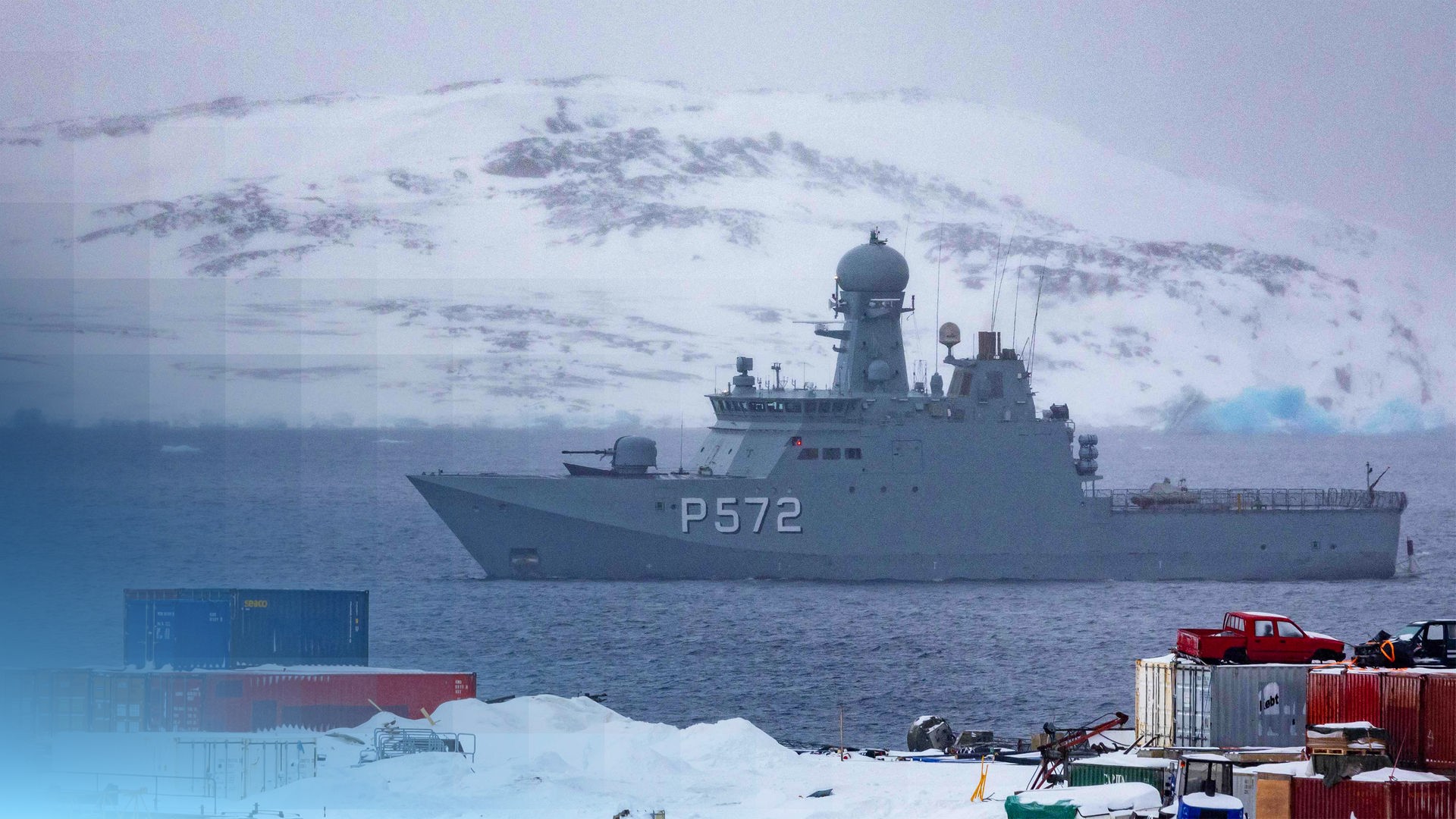 Ein Militärschiff in der Arktis. Im Hintergund ist ein schneebedeckter Berg.