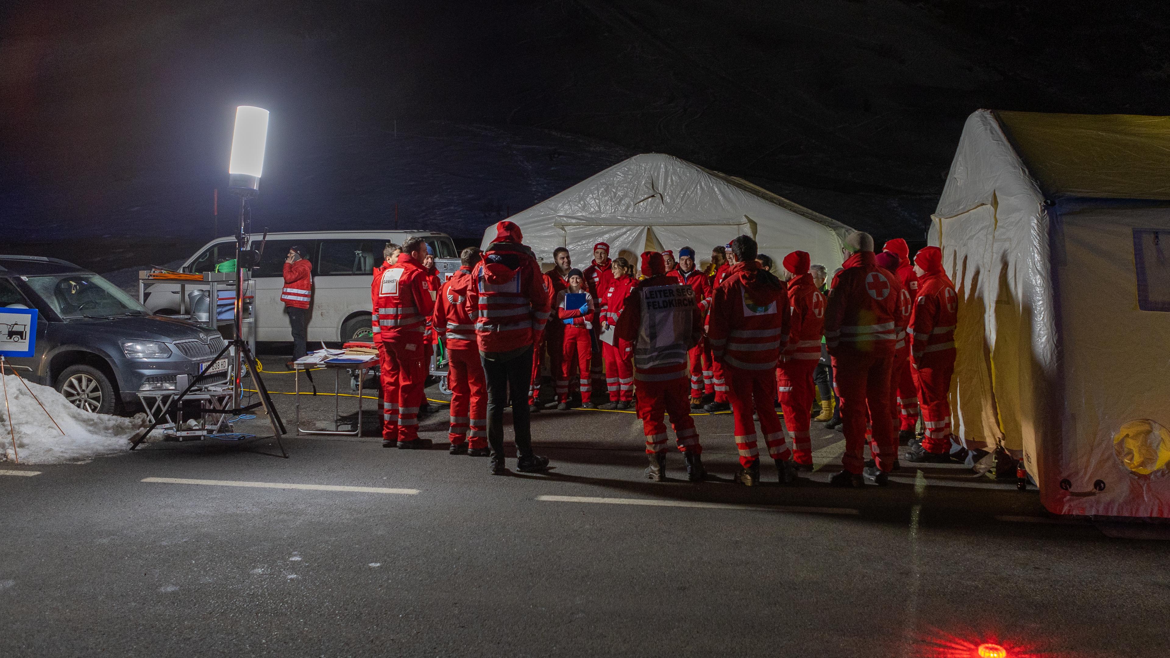 Einsatzkräfte stehen vor Notunterkünften am Arlberg in Österreich