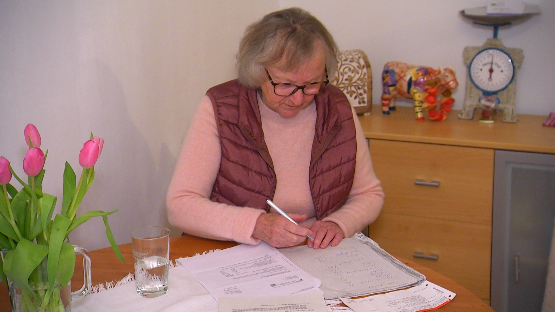 Die Rentnerin Theres Nieder sitzt an ihrem Esstisch und füllt ein Formular aus.