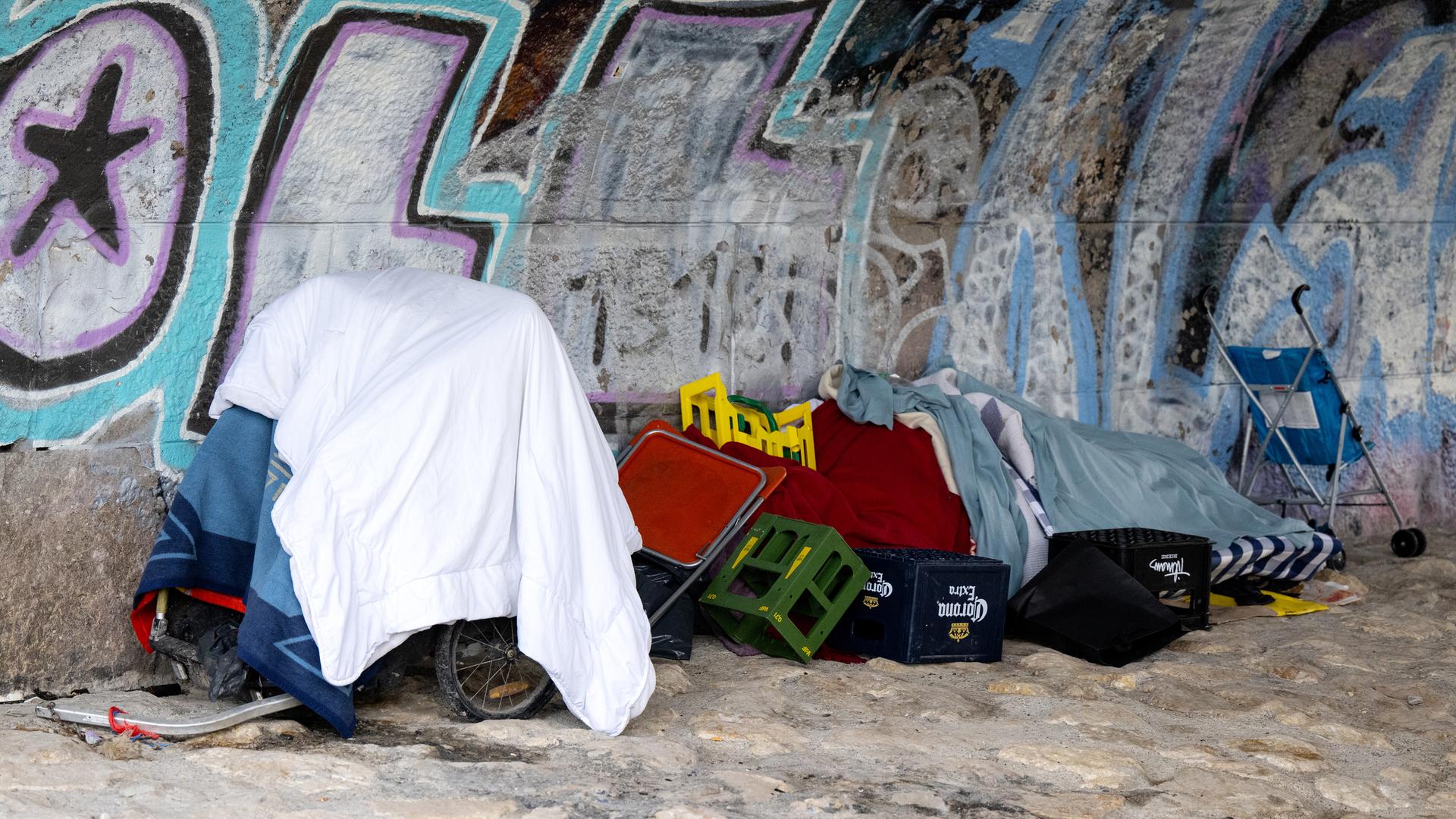 Die Habseligkeiten von einem Obdachlosen liegen am Ufer der Isar unter einer Brücke, aufgenommen am 27.04.2023 in München