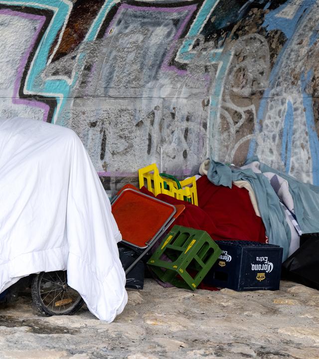 Die Habseligkeiten von einem Obdachlosen liegen am Ufer der Isar unter einer Brücke, aufgenommen am 27.04.2023 in München