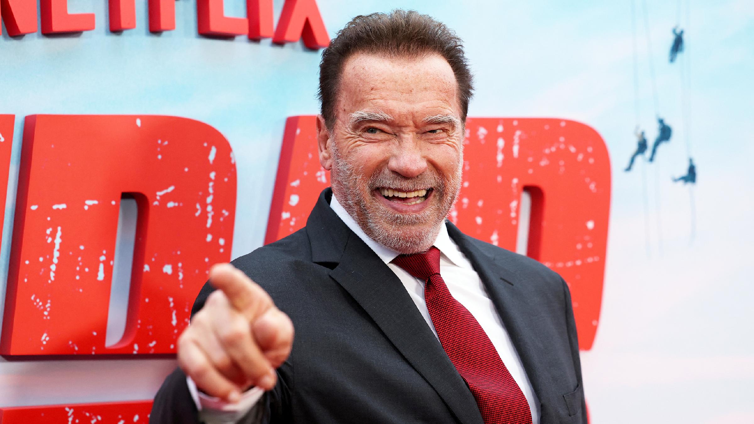 Arnold Schwarzenegger auf einem roten Teppich.