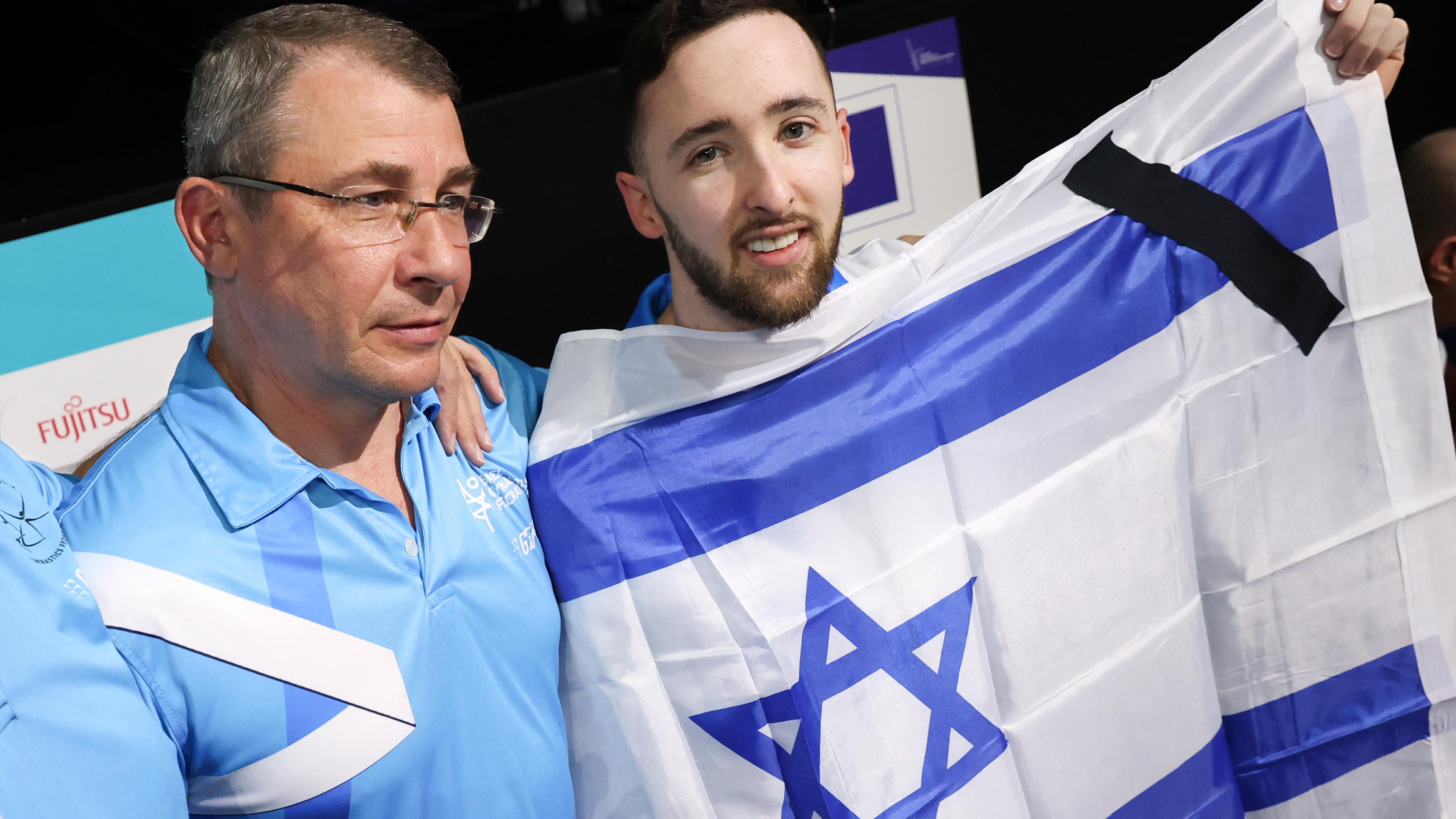 Turner Artem Dolgopyat hält bei der WM-Siegerehrung eine israelische Fahne