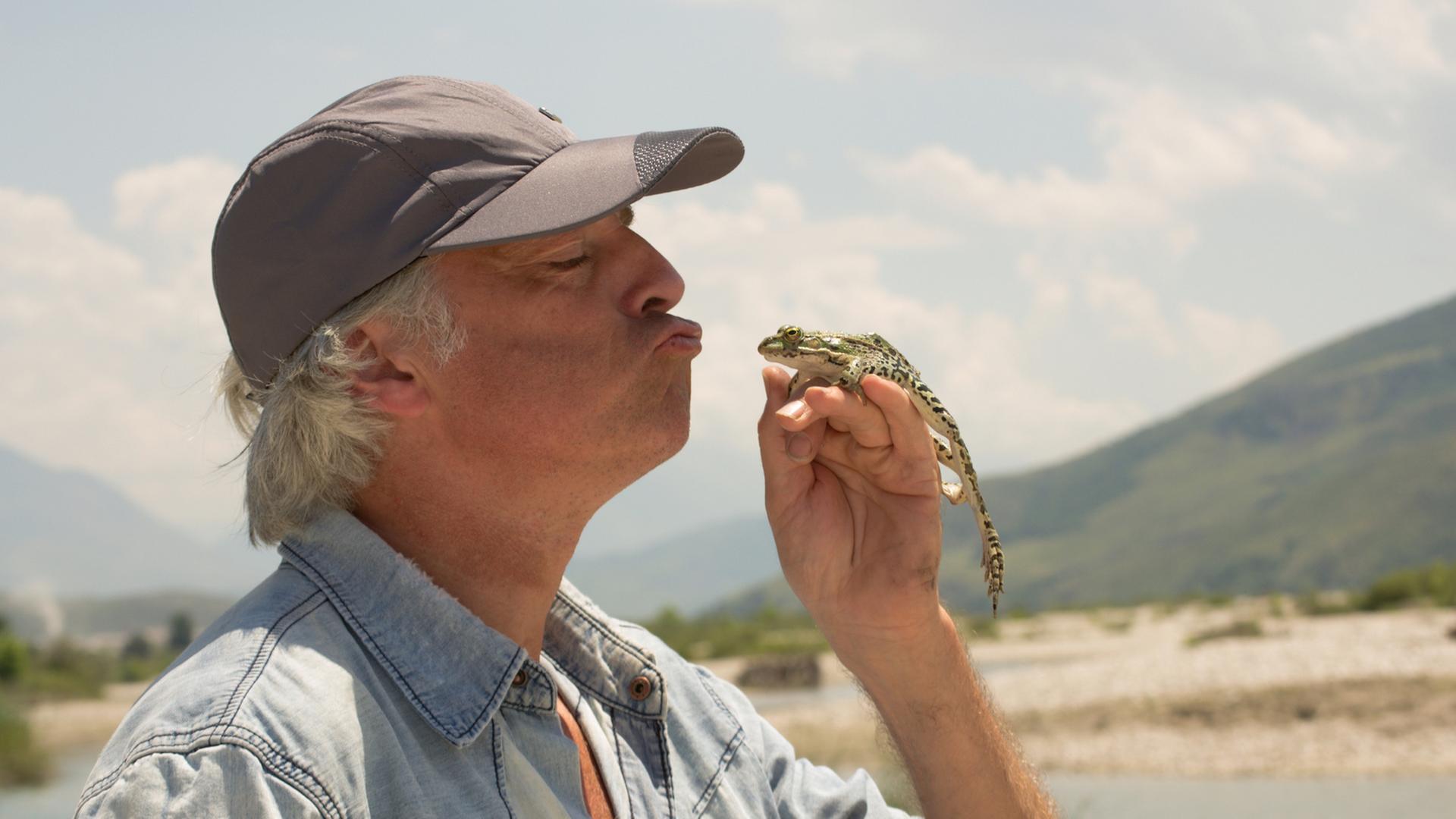 Artenschützer Ulrich Eichelmann küsst einen Frosch