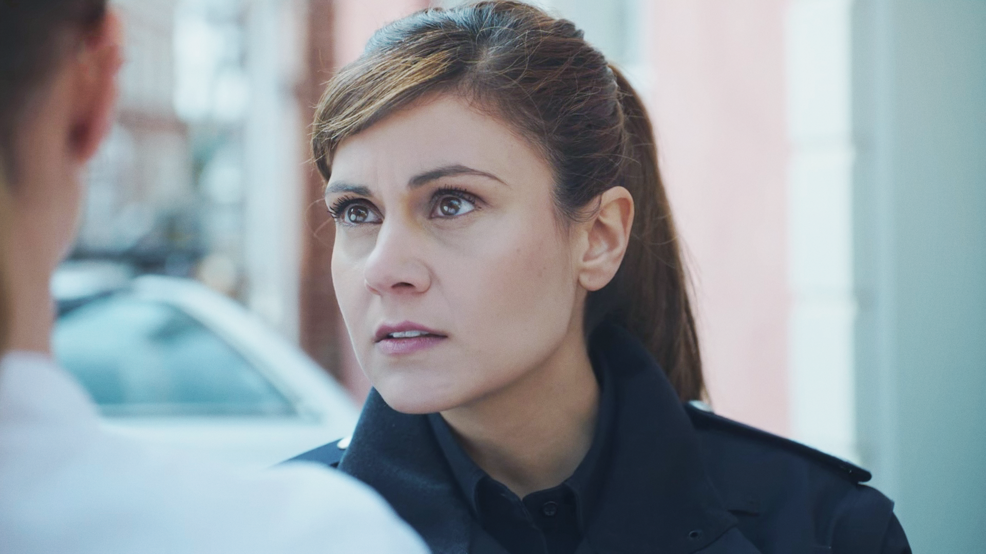 Süher Özlügül (Sophie Dal) in Großaufnahme, wie sie mit einem Mann spricht. 